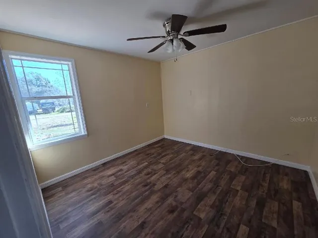 a view of a room with wooden floor and a window