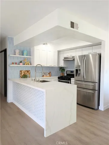 a kitchen with a refrigerator a stove a microwave and cabinets