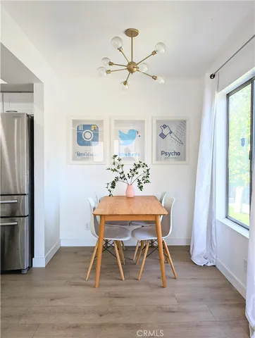 a living room with stainless steel appliances kitchen island a table and a refrigerator