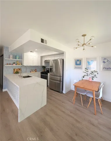 a dining room with wooden floor and a chandelier