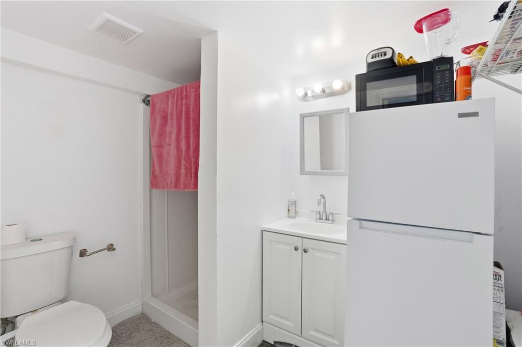 5431 Oak Ridge Avenue Fort Myers Beach, FL 33931 - Photo 12 of 33 a bathroom with a sink vanity mirror and toilet