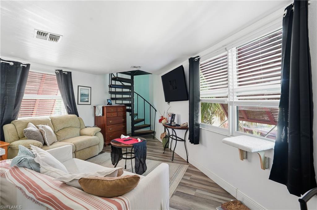 5431 Oak Ridge Avenue Fort Myers Beach, FL 33931 - Photo 15 of 33 a living room with furniture a flat screen tv and a large window
