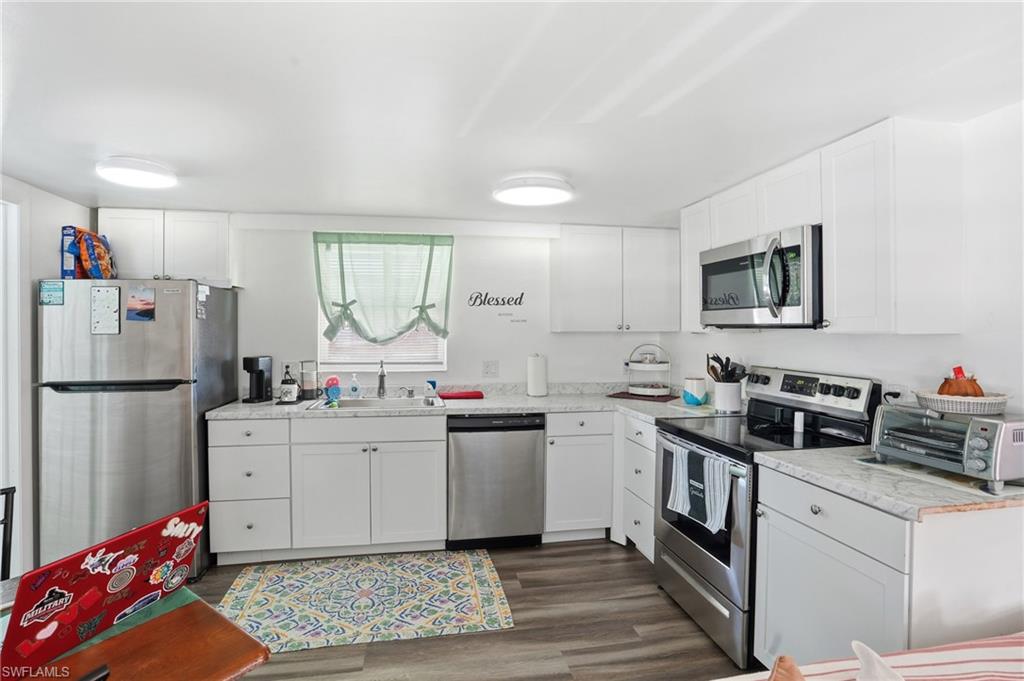 5431 Oak Ridge Avenue Fort Myers Beach, FL 33931 - Photo 16 of 33 a kitchen with a sink stove and refrigerator