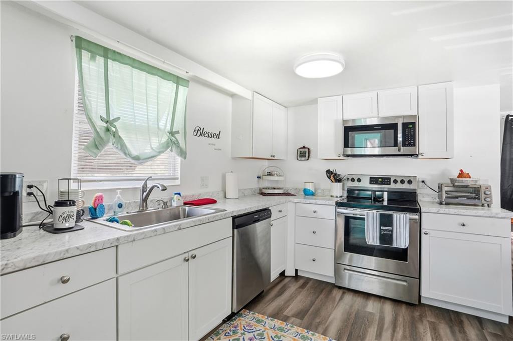 5431 Oak Ridge Avenue Fort Myers Beach, FL 33931 - Photo 17 of 33 a kitchen with a sink stove and microwave