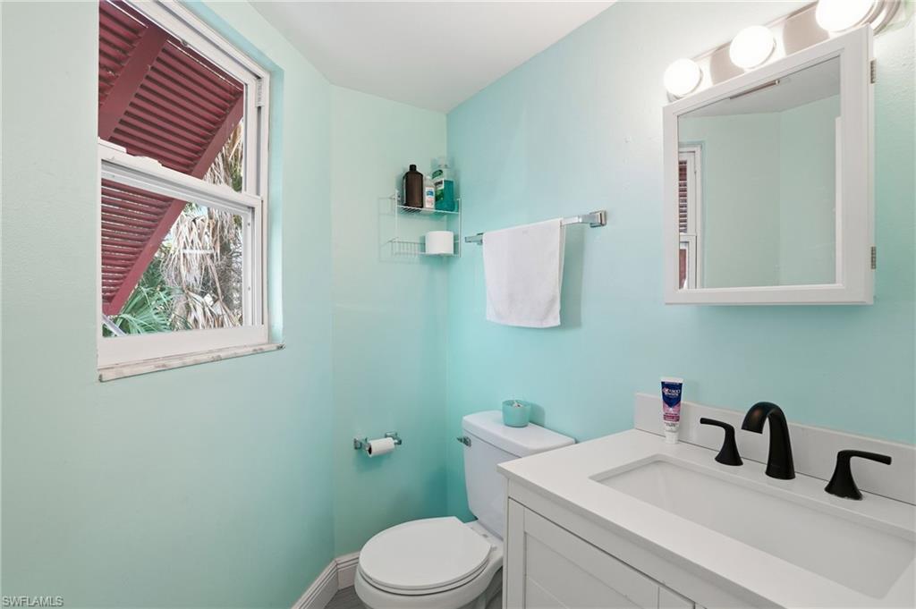 5431 Oak Ridge Avenue Fort Myers Beach, FL 33931 - Photo 19 of 33 a bathroom with a sink mirror and vanity