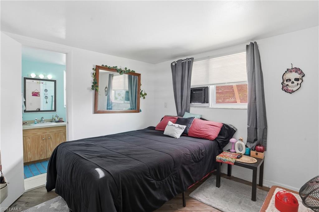 5431 Oak Ridge Avenue Fort Myers Beach, FL 33931 - Photo 24 of 33 a bedroom with a bed and wooden floor