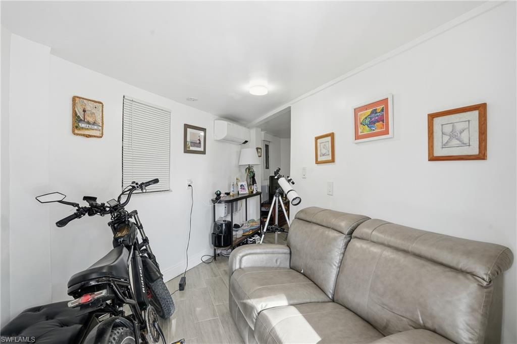 5431 Oak Ridge Avenue Fort Myers Beach, FL 33931 - Photo 7 of 33 a living room with furniture a flat screen tv and a wooden floor