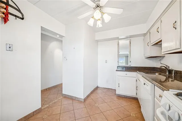 a kitchen with granite countertop white cabinets and white appliances