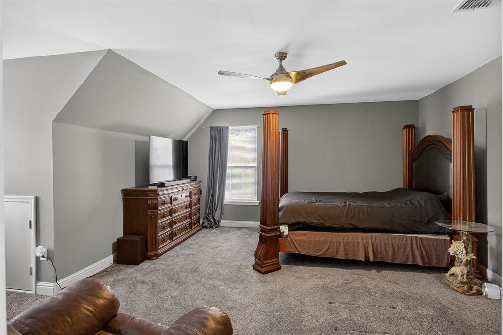 720 Haggerty Road Karnack, TX 75661 - Photo 21 of 39 a bedroom with a bed and a chandelier