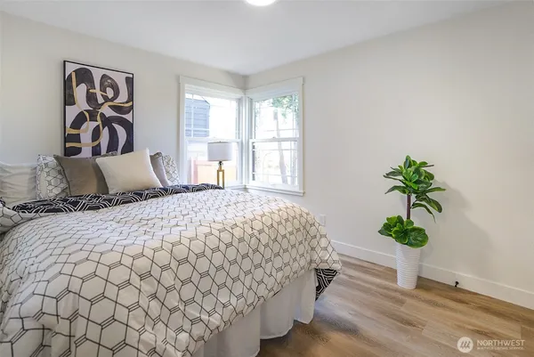 a bedroom with a large bed and a potted plant