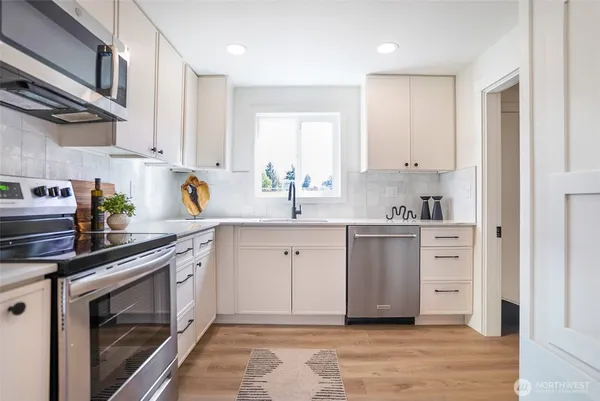 a kitchen with white cabinets and white appliances