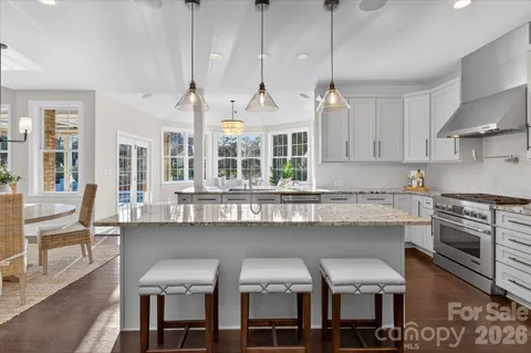 a kitchen with a dining table chairs cabinets and stainless steel appliances