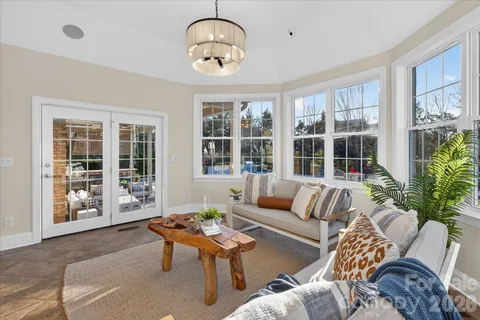 a living room with furniture and floor to ceiling windows