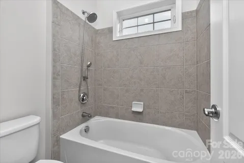 a large bed sitting in a bedroom next to a window and a chandelier