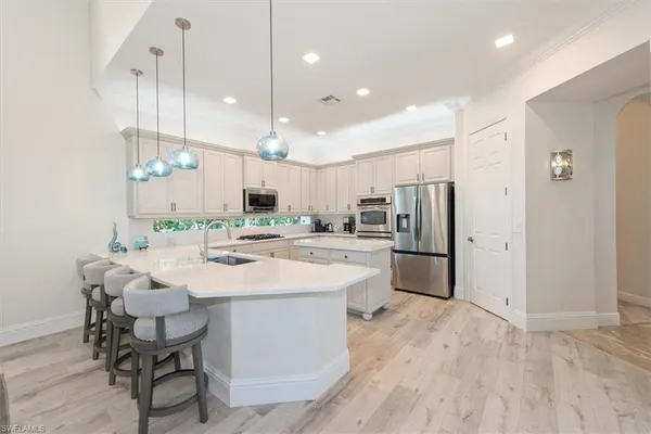 a kitchen with kitchen island white cabinets and stainless steel appliances