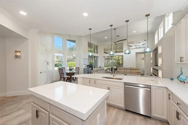 a kitchen with stainless steel appliances a sink a stove a refrigerator and white cabinets