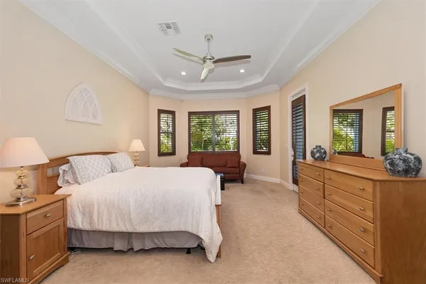 a spacious bedroom with a large bed and a chandelier