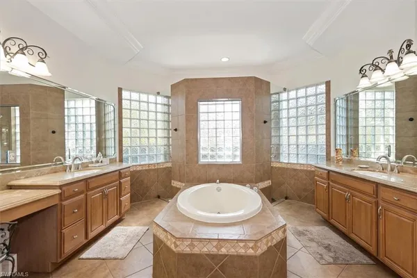 a bathroom with a granite countertop tub sink and mirror