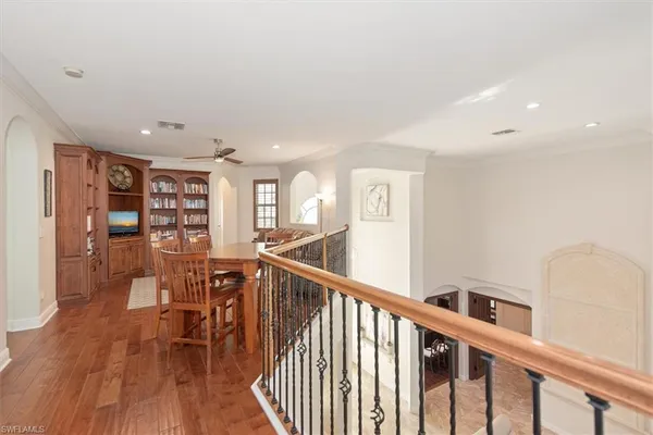 a view of a hallway with wooden floor and furniture