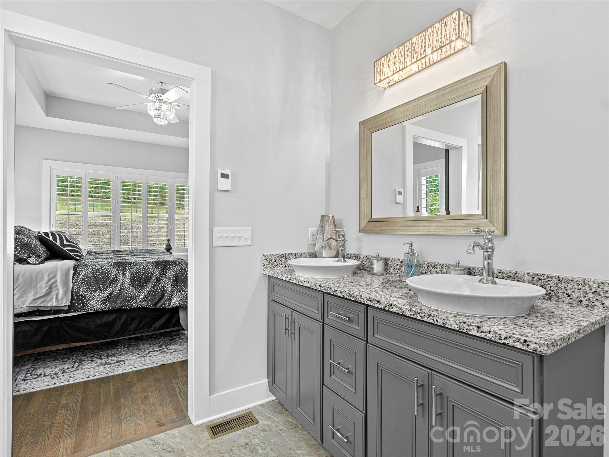 139 Clay Street Fairview, NC 28730 - Photo 25 of 35 a en suite bathroom with a granite countertop sink and a mirror