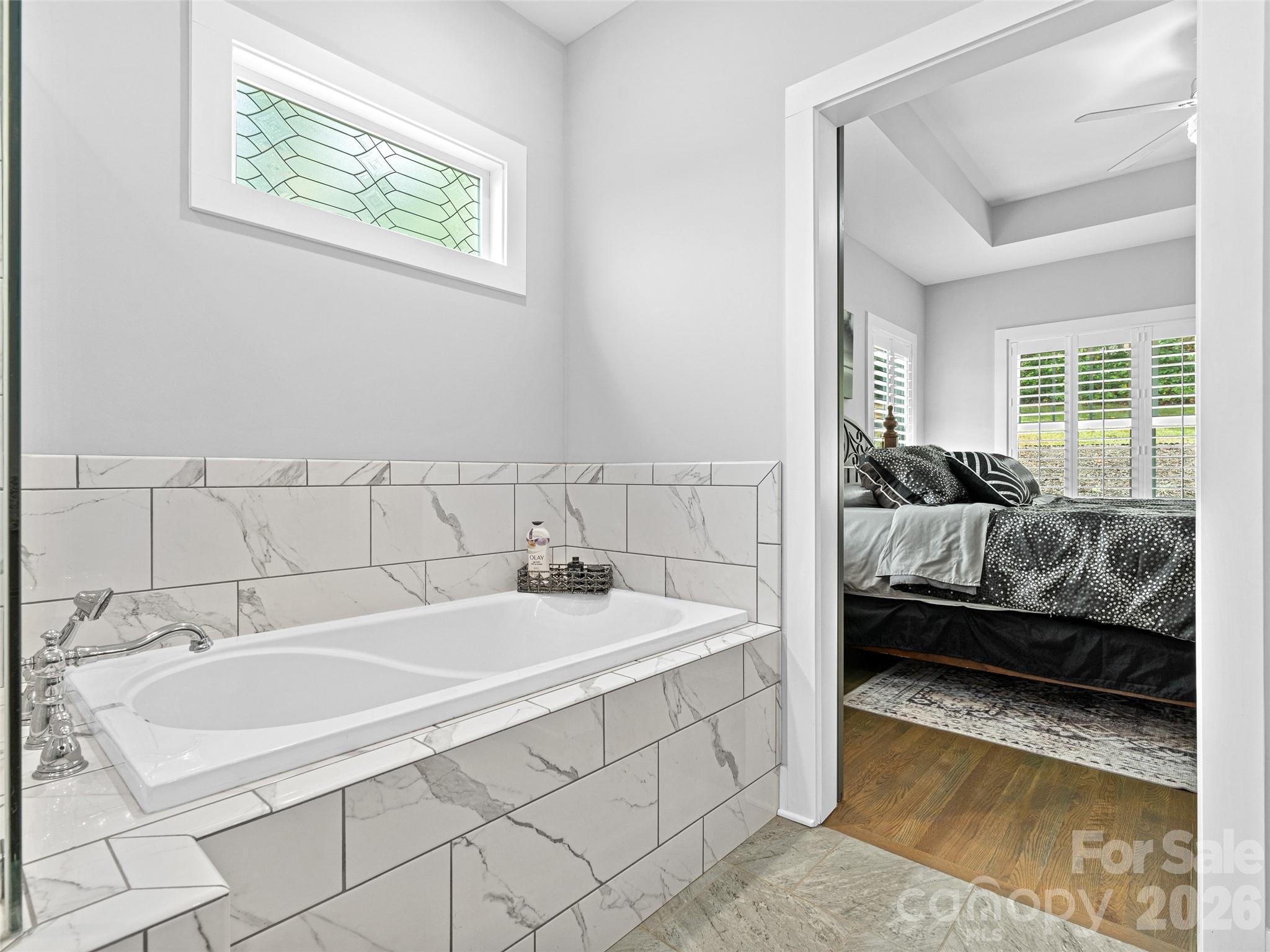 139 Clay Street Fairview, NC 28730 - Photo 26 of 35 a en suite bathroom with a granite countertop tub and a sink