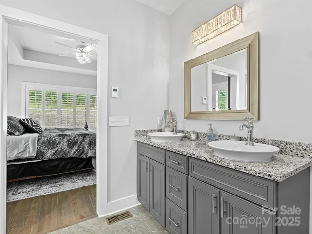 a en suite bathroom with a granite countertop tub and a sink