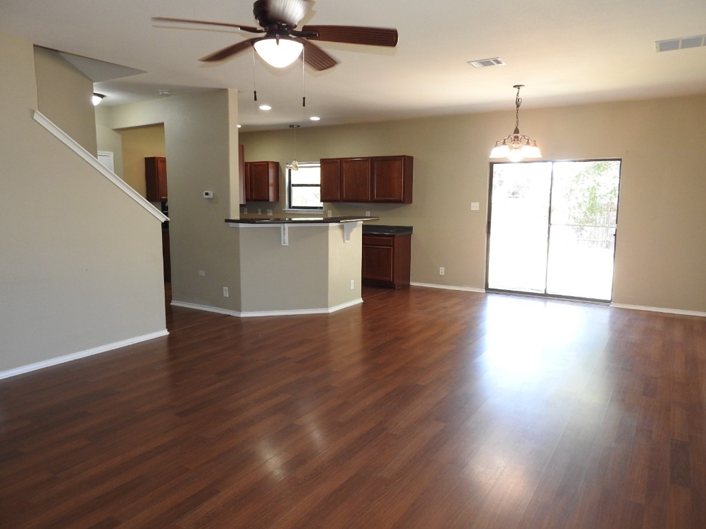 571 New Country Road Kyle, TX 78640 - Photo 2 of 21 an empty room with wooden floor and windows