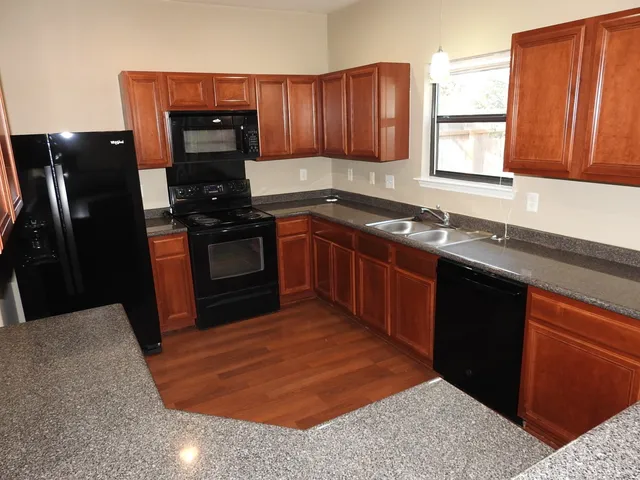 a kitchen with stainless steel appliances granite countertop a sink stove and refrigerator