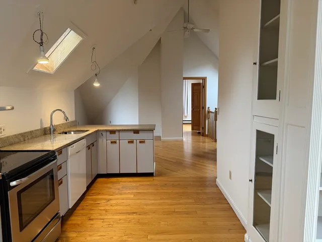 a large white kitchen with a sink a stove and a refrigerator