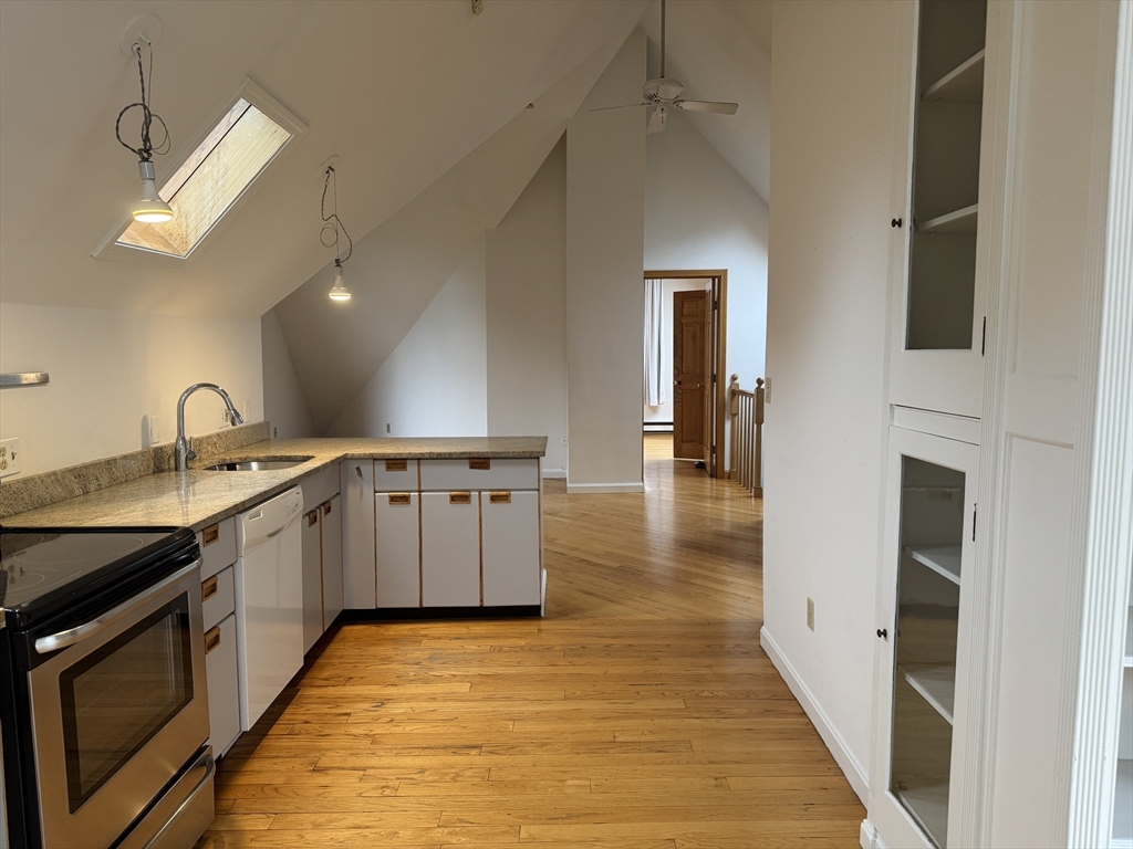 82 Hammond Street, Unit 3 Cambridge, MA 02138 - Photo 3 of 13 a large white kitchen with a sink a stove and a refrigerator