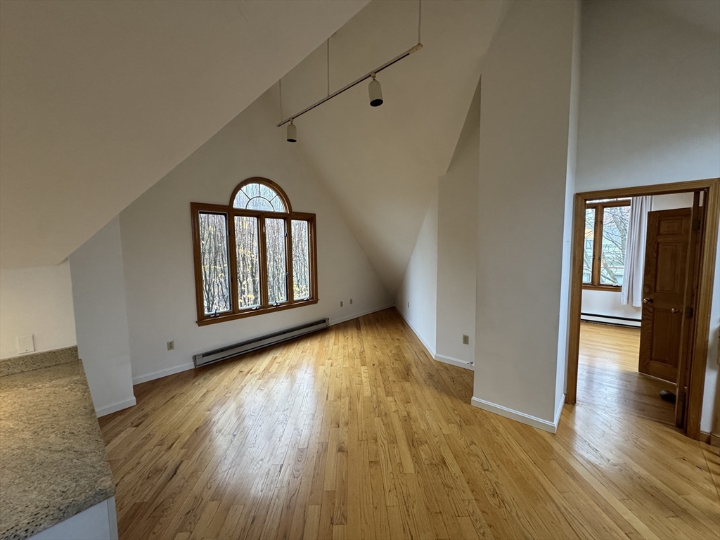 82 Hammond Street, Unit 3 Cambridge, MA 02138 - Photo 4 of 13 wooden floor in an empty room with a window