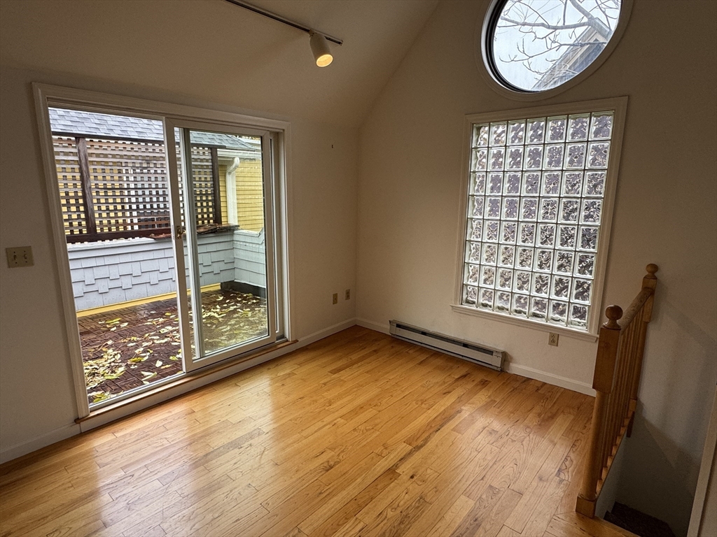 82 Hammond Street, Unit 3 Cambridge, MA 02138 - Photo 7 of 13 an empty room with wooden floor and windows