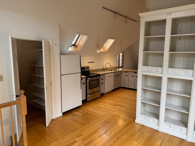 a kitchen with stainless steel appliances granite countertop a refrigerator and a stove top oven