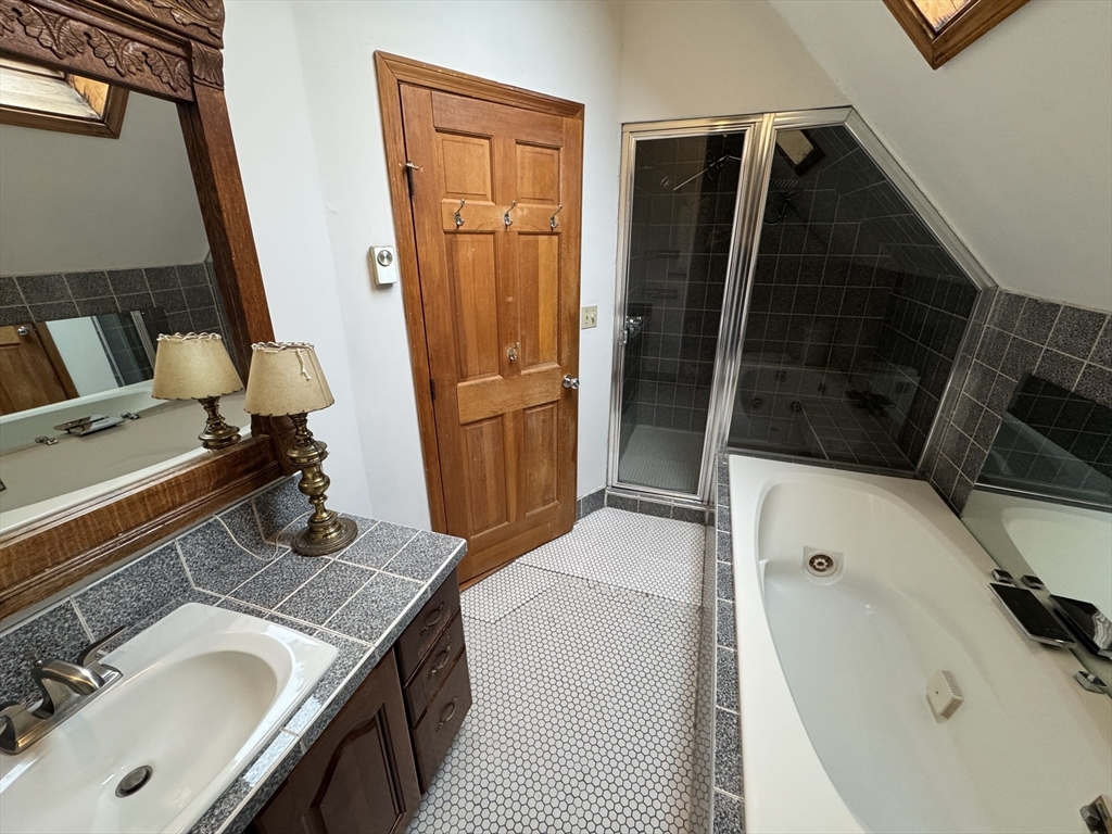 82 Hammond Street, Unit 3 Cambridge, MA 02138 - Photo 10 of 13 a bathroom with a granite countertop sink and a mirror