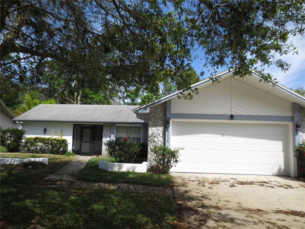 3235 East Dorchester Drive Palm Harbor, FL 34684 - Photo 1 of 47 a front view of a house with a yard and garage