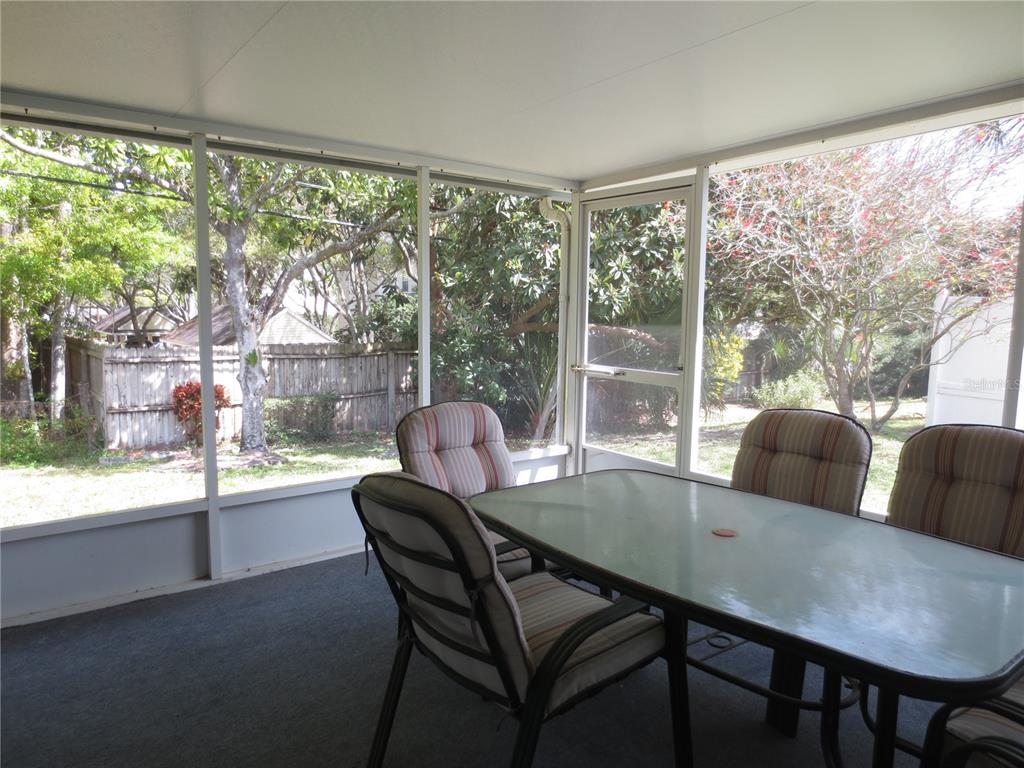 3235 East Dorchester Drive Palm Harbor, FL 34684 - Photo 23 of 47 a view of a dining room with furniture large windows and wooden floor