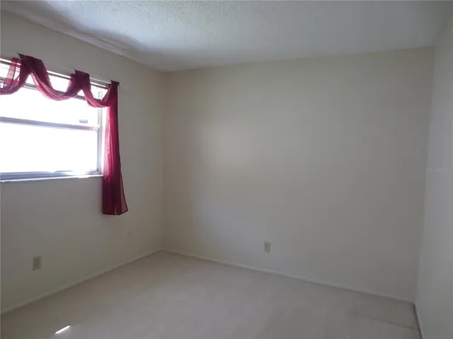 a view of a big room with windows and chandelier fan