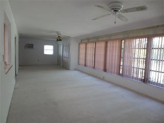 a view of a room with windows and ceiling fan