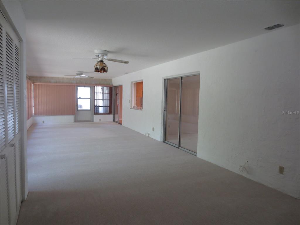 3235 East Dorchester Drive Palm Harbor, FL 34684 - Photo 46 of 47 a view of a big room with windows and chandelier fan