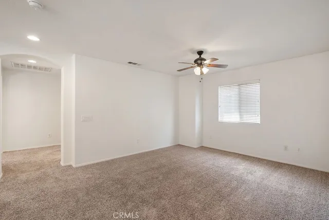 a view of an empty room with a ceiling fan and a window