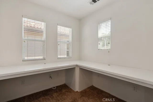 an empty room with a window and ceiling fan