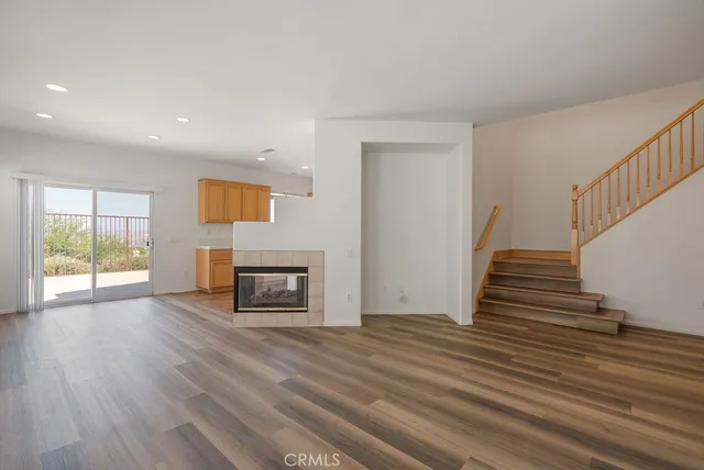 a view of a livingroom with wooden floor and a fireplace