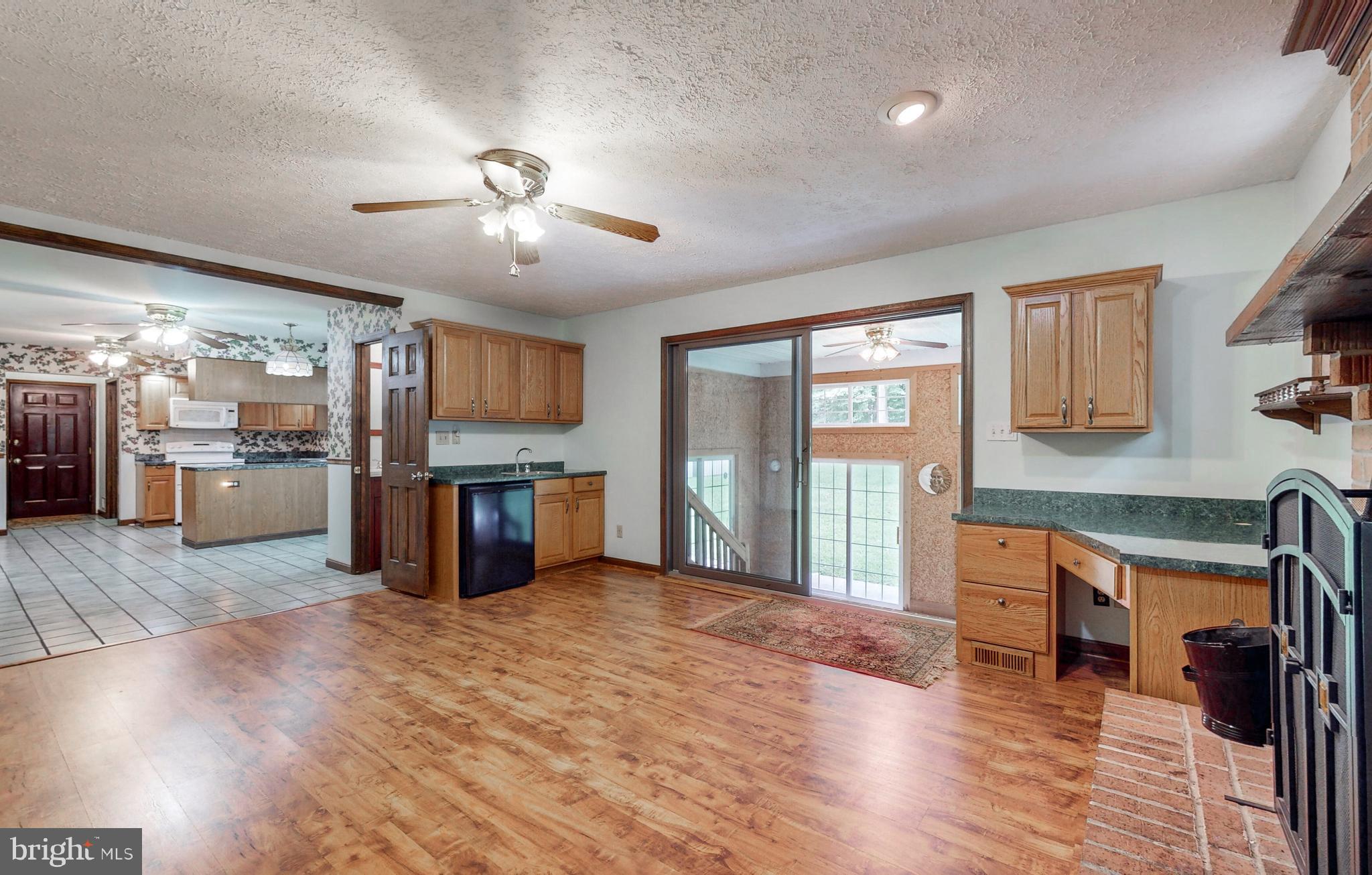 2021 Oakmont Road Fallston, MD 21047 - Photo 18 of 50 a open kitchen with stainless steel appliances granite countertop a refrigerator a sink dishwasher a stove and a dining table with wooden floor