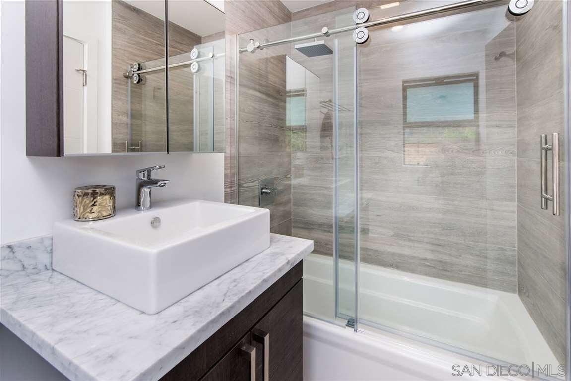 1402 Rodeo Drive La Jolla, CA 92037 - Photo 20 of 42 a white bath tub sitting next to a white sink and a shower