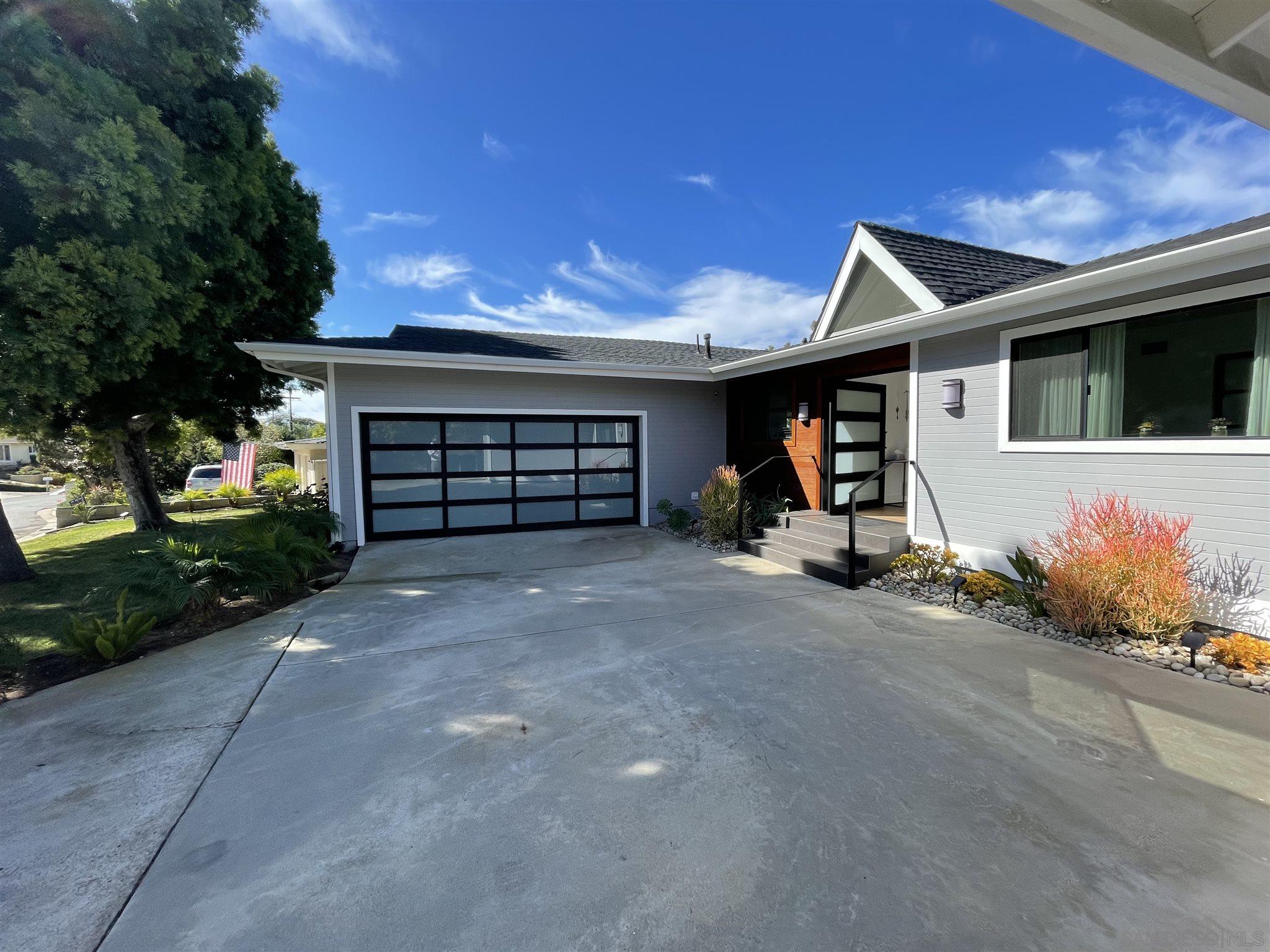1402 Rodeo Drive La Jolla, CA 92037 - Photo 32 of 42 a view of a house with a yard and garage