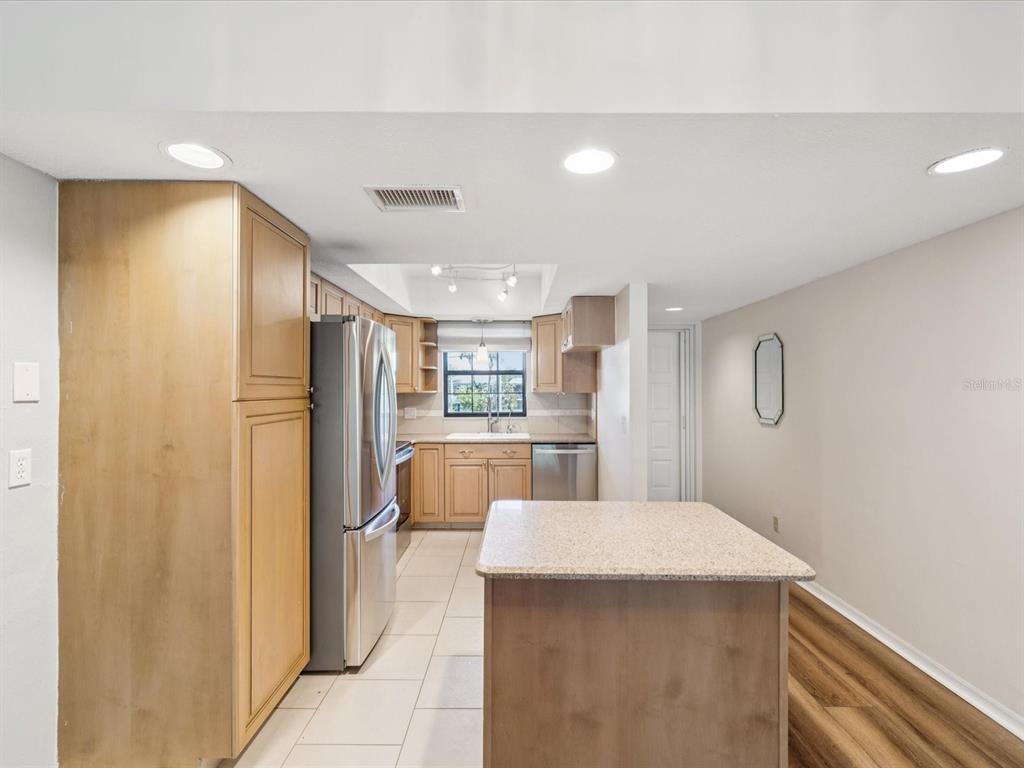 12900 Vonn Road, Unit E203 Largo, FL 33774 - Photo 4 of 26 a kitchen with refrigerator and white cabinets