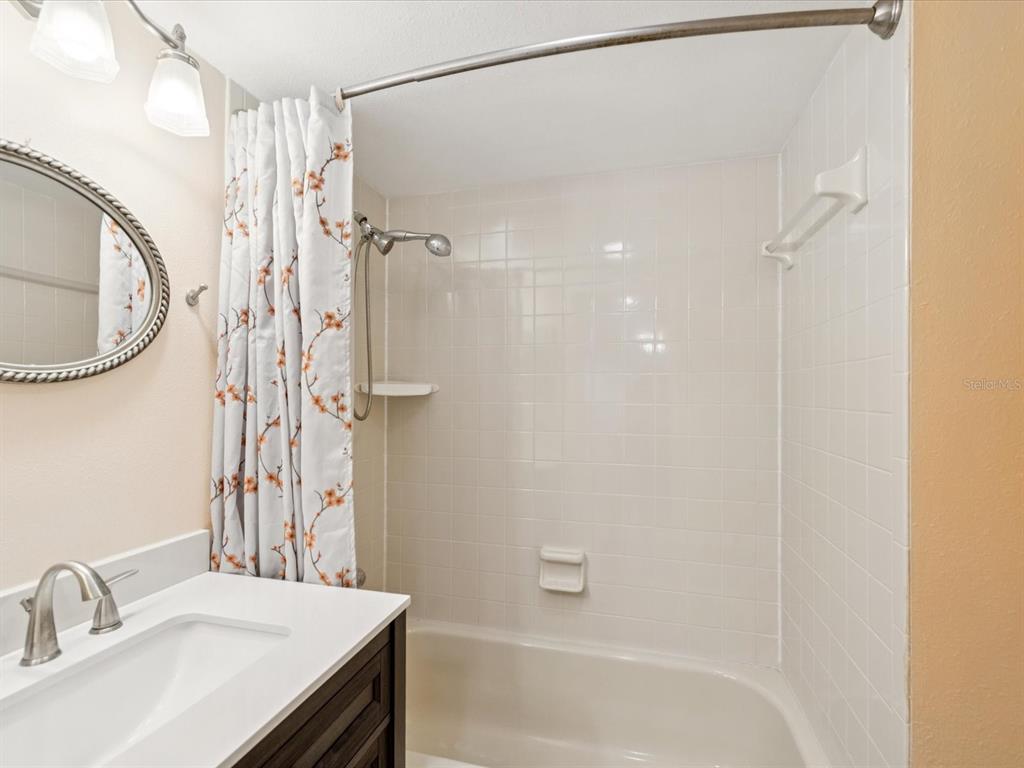 12900 Vonn Road, Unit E203 Largo, FL 33774 - Photo 5 of 26 a bathroom with a granite countertop sink a toilet and shower