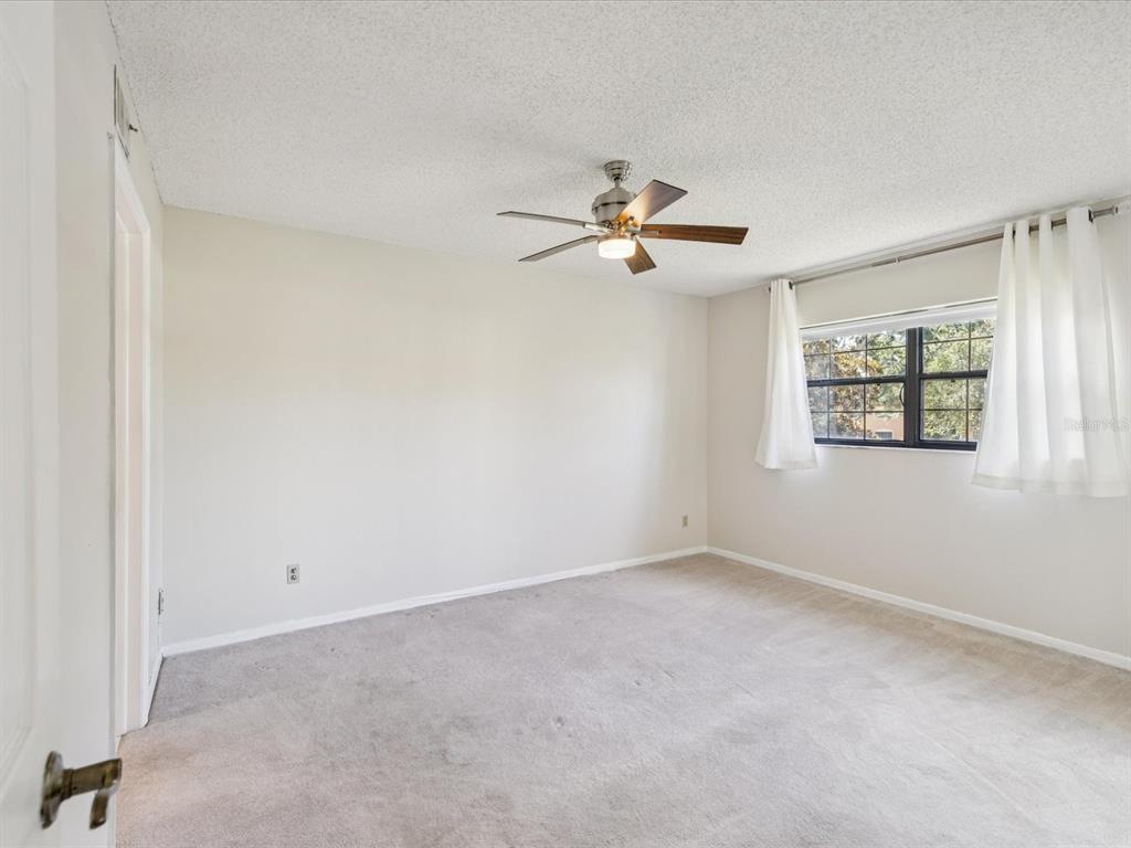 12900 Vonn Road, Unit E203 Largo, FL 33774 - Photo 10 of 26 an empty room with windows and ceiling fan