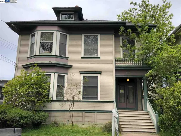 a view of a house with large windows and a small yard