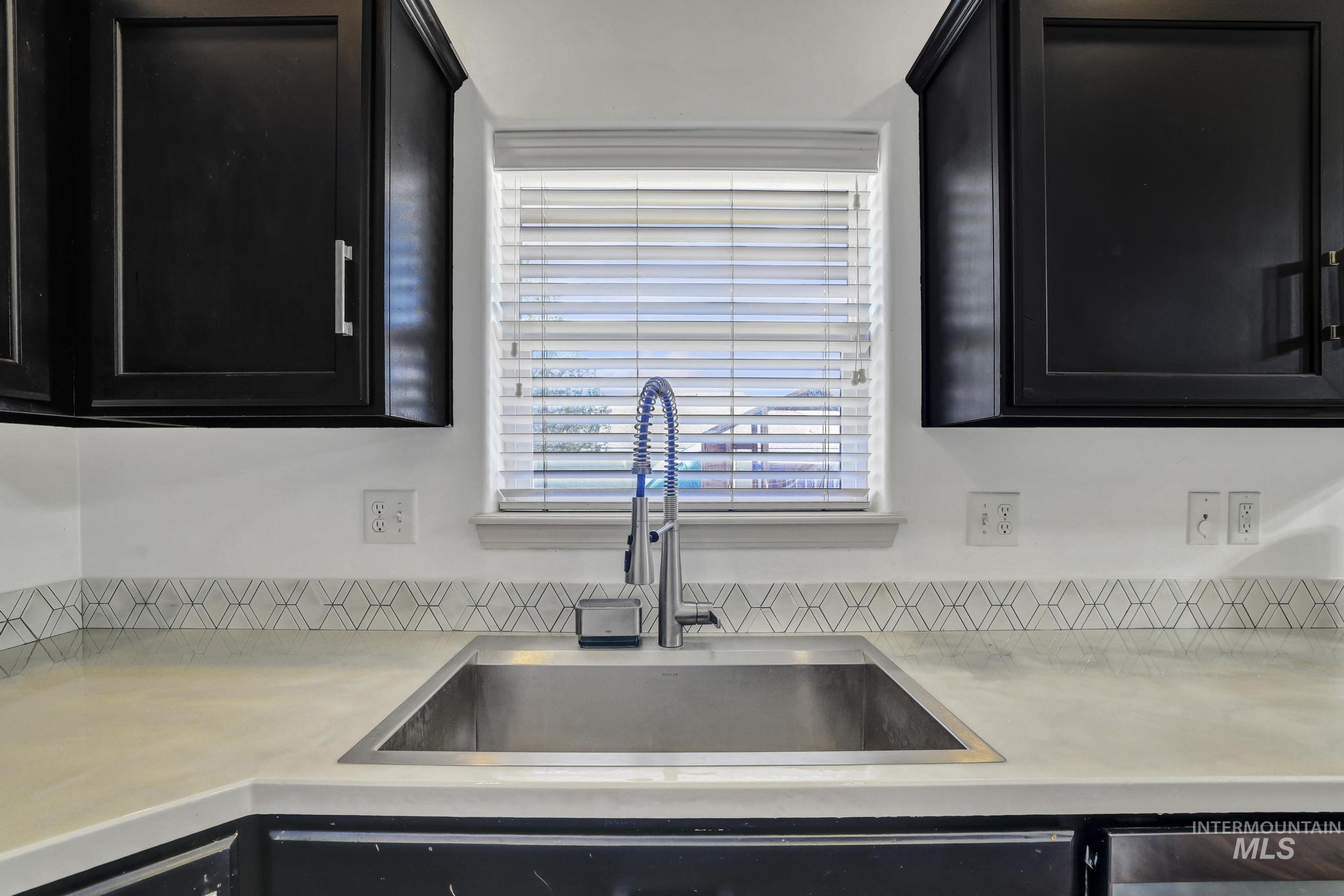 446 Noble Street Twin Falls, ID 83301 - Photo 10 of 42 Kitchen sink area featuring an undermount stainless steel sink, a professional-style pull-down faucet, and light-toned countertops